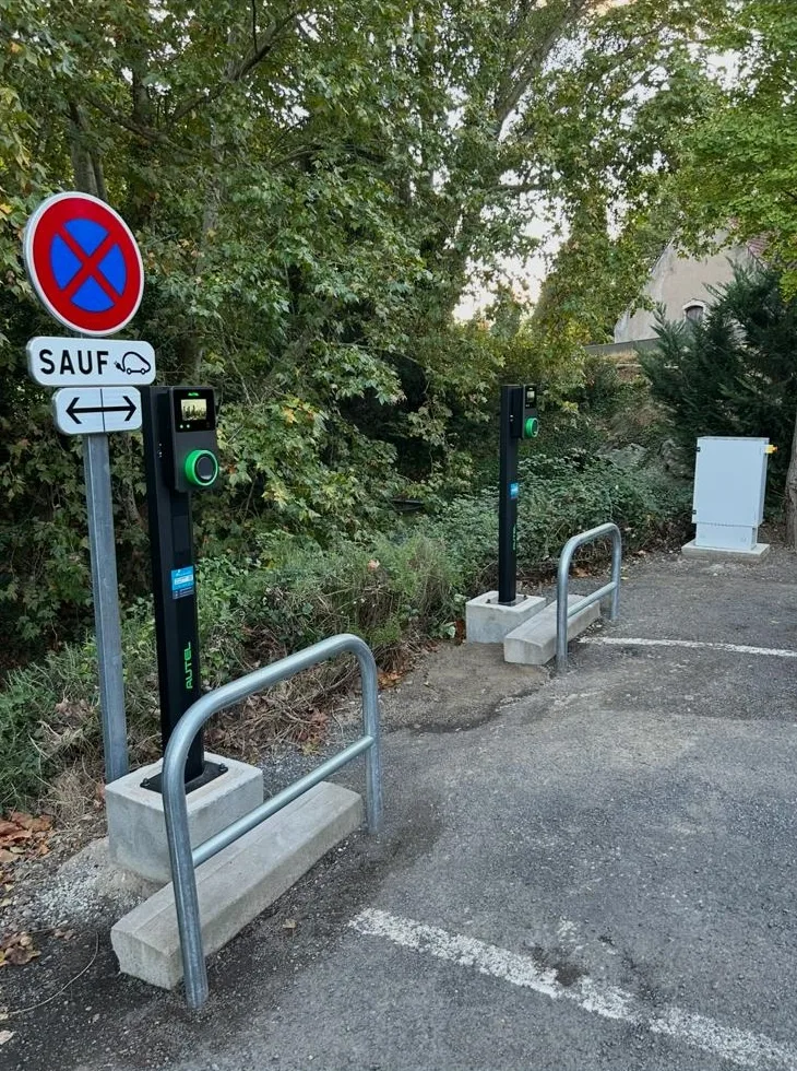 Deux bornes de recharge sur pied installées côte à côte sur une aire de stationnement